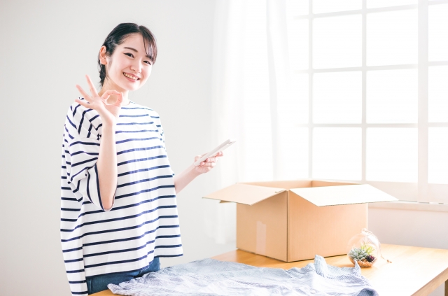 洋服をフリマアプリに出品する女性の画像
