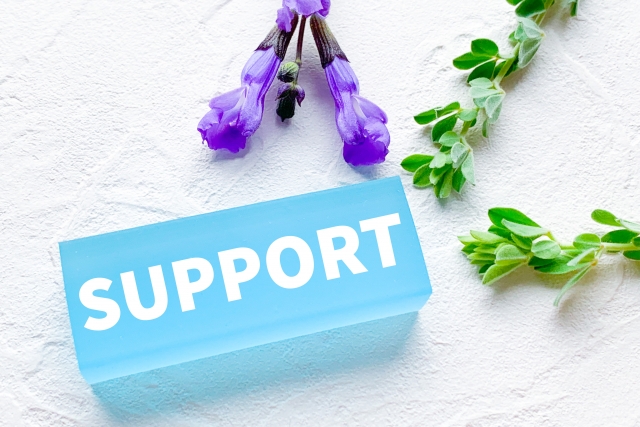 「SUPPORT」と書かれたブロックの周辺に、お花と葉っぱが置かれている画像
