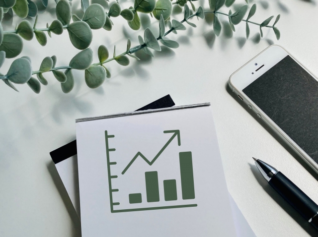 グラフが印刷されたノートとペン・スマートフォンの画像