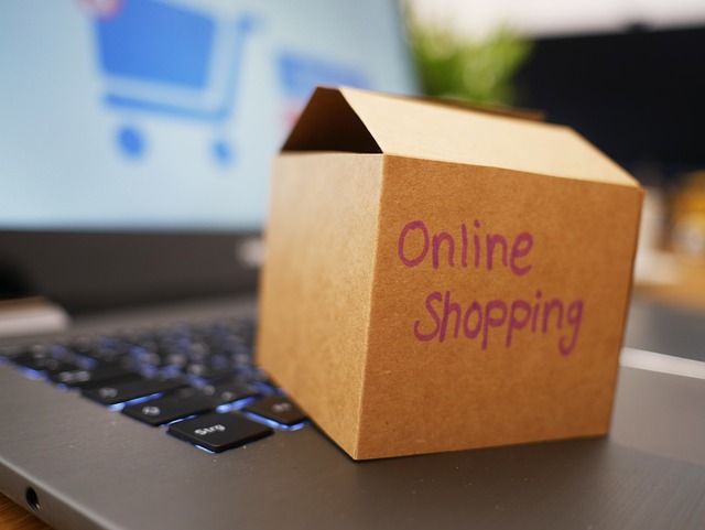 パソコンの上に「online shopping」と書かれた箱が置かれている画像